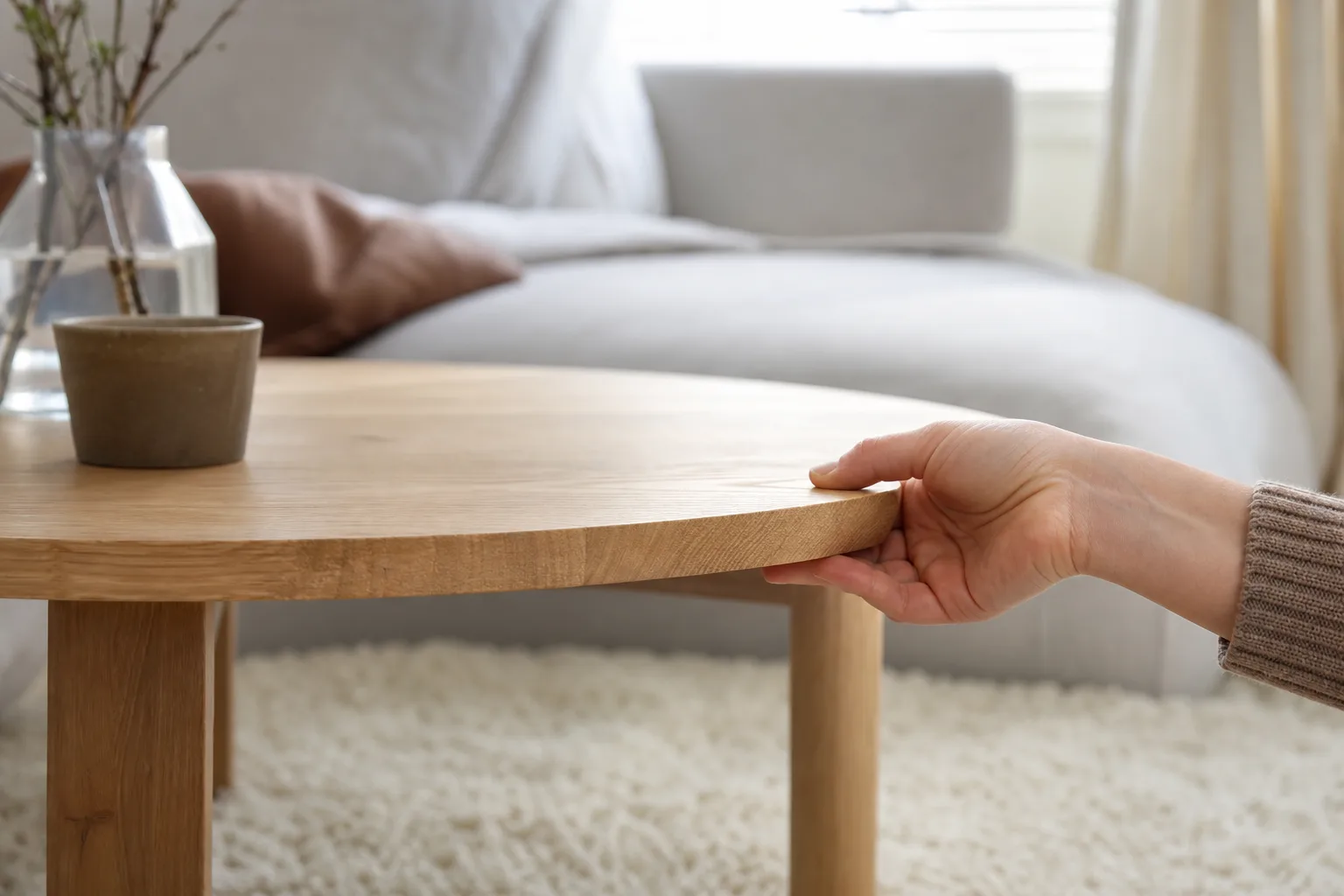 Hand visar kanten och träådringen på soffbord i ek